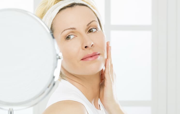 Woman looking into a small mirror